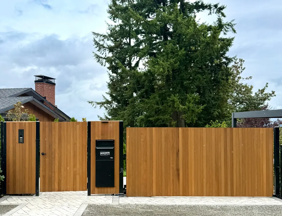Clear cedar tongue-and-groove vertical fence with metal framing and electronic walk-in and automatic driveway gates, installed in the Portland metro area by Masters Construction Group