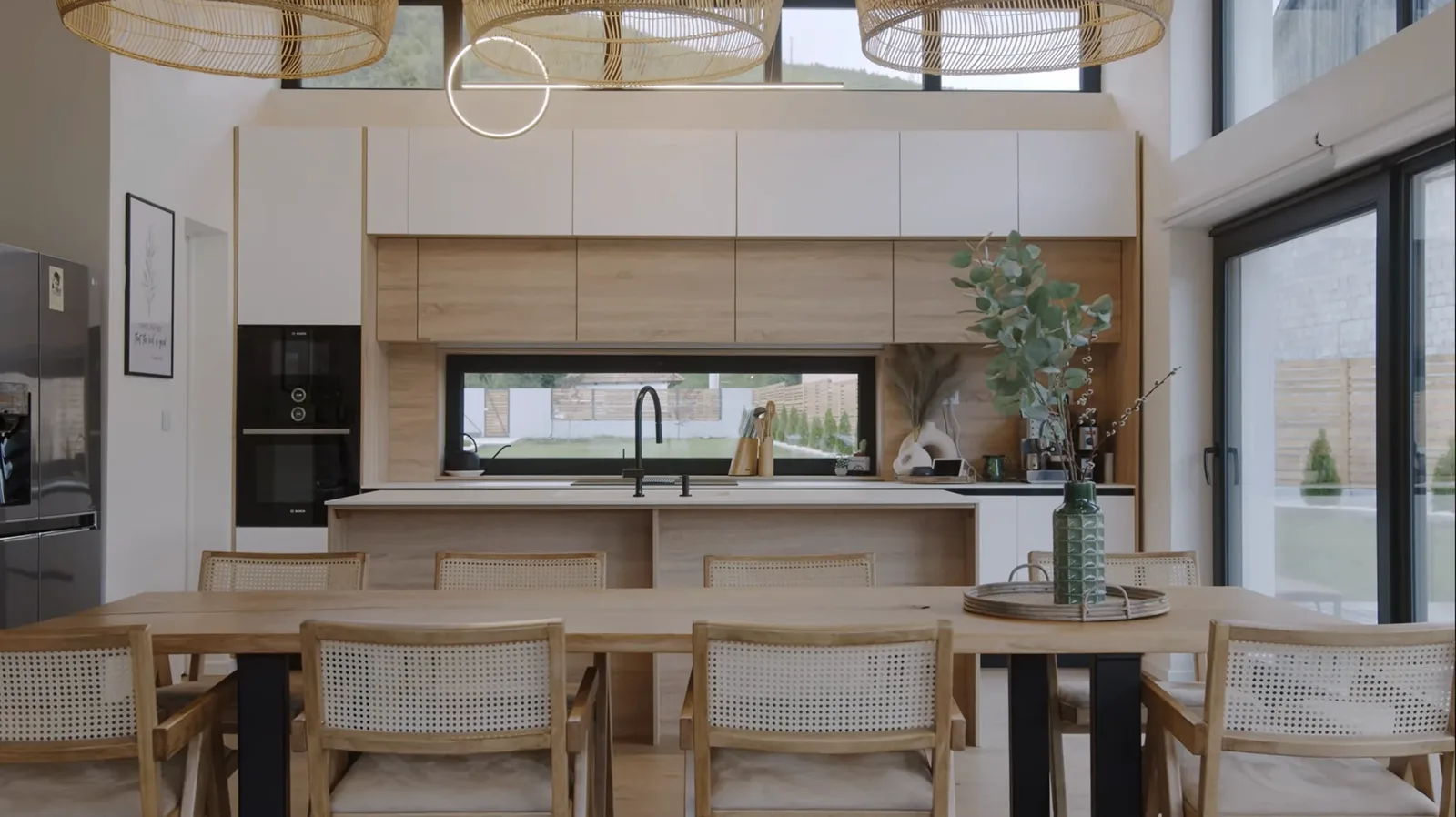 Modern open-concept kitchen remodel in Oregon City with light oak cabinetry, white quartz island, integrated Bosch appliances, and dining area by Masters Construction